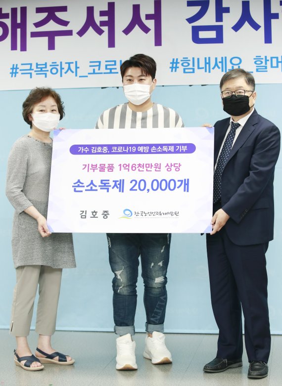 ‘미스터트롯’ 김호중(가운데)이 18일 경기도 일산동구 한국노인인력개발원에서 열린 코로나19 감염병 예방을 위한 ‘손 소독제 기부물품 전달식’에 참석해 강익구 한국노인인력개발원 원장, 김해인 고양시니어틀럽 대표(왼쪽)와 함께 포즈를 취하고 있다. 2020.6.18./뉴스1 © News1 권현진 기자