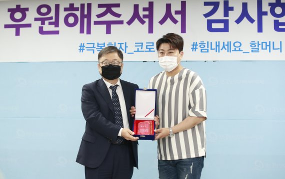 ‘미스터트롯’ 김호중(오른쪽)이 18일 경기도 일산동구 한국노인인력개발원에서 열린 코로나19 감염병 예방을 위한 ‘손 소독제 기부물품 전달식’에 참석해 강익구 한국노인인력개발원 원장에게 감사패를 받은 뒤 포즈를 취하고 있다. 2020.6.18./뉴스1 © News1 권현진 기자