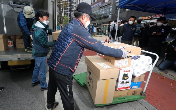 지난 16일 오후 단지 내 택배차량 진입이 제한된 서울 강동구 고덕동에 위치한 5000가구 규모 아파트 앞에서 한 택배노동자가 기자회견을 마친 뒤 택배 배송 물품들을 손수레에 실어 개별 배송을 하고 있다. 뉴스1 제공