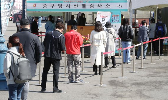 코로나19 신규 확진자 672명을 기록한 18일 오전 서울역 광장에 마련된 임시선별진료소에서 시민들이 길게 줄을 서고 있다. 사진=박범준 기자