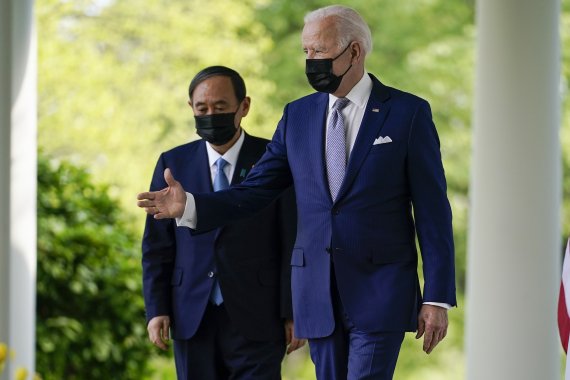 조 바이든 미국 대통령(오른쪽)이 16일(현지시간) 미 워싱턴DC 백악관에서 스가 요시히데 일본 총리와 함께 기자회견장으로 이동하고 있다. 이날 두 정상은 한목소리로 중국을 견제하기 위해 협력하겠다고 밝혔다. AP뉴시스