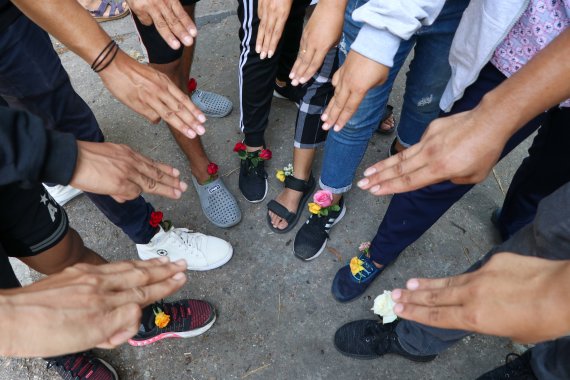 [양곤=AP/뉴시스]8일 미얀마 양곤에서 반 쿠데타 시위대가 신발에 꽃을 꽂은 채 저항의 상징인 세 손가락을 펴 보이며 카마윳 지역에 모여 있다. 이들은 반 군부 구호를 외치며 마을과 시장을 돌면서 시위를 벌였다. 2021.04.08. /사진=뉴시스