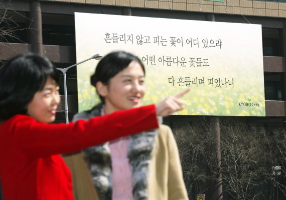 지난 2004년 교보생명 광화문 글판에 걸린 도종환의 시 '흔들리며 피는 꽃' 속 글귀가 행인들의 눈길을 사로잡고 있다. 교보생명 제공