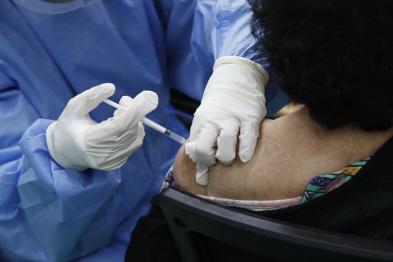 지난 20일 서울 동대문구 동대문구체육관 코로나19접종센터에서 한 시민이 75세 이상 어르신에 대한 예방접종을 받고 있다. 뉴시스 제공