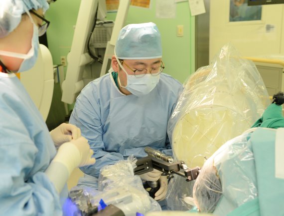 장원석 교수가 국내 최초로 개발된 뇌수술 보조 로봇장비인 카이메로를 이용해 환자의 뇌심부에 전극을 삽입하고 있다. 카이메로를 이용한 뇌전증 수술은 약 2~3mm의 작은 구멍으로 전극을 삽입할 수 있어 수술시간도 짧고, 부작용이나 수술 후 통증도 줄일 수 있다. 사진=세브란스병원