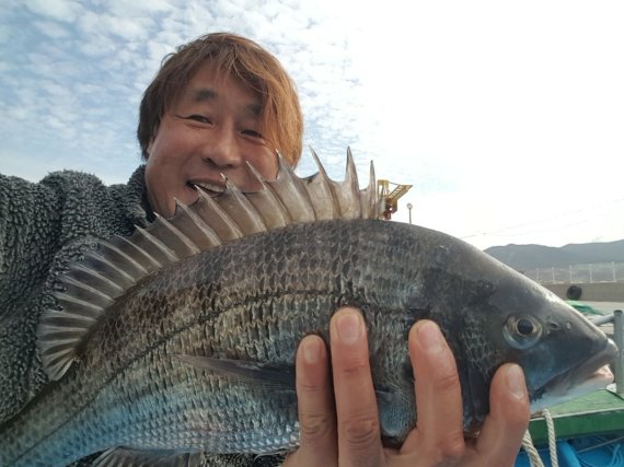 경남 거제시 일운면 옥화마을로 귀어한 홍수명 이장이 물고기를 들고 있다. © 뉴스1