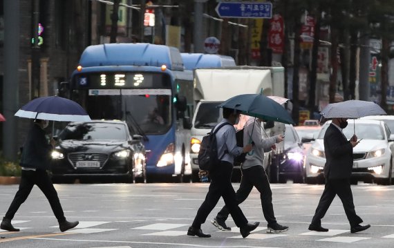 [서울=뉴시스]조수정 기자 = 봄비가 내리는 4일 오전 서울 중구 을지로에서 시민들이 우산을 들고 출근길 발걸음을 재촉하고 있다. 2021.05.04. chocrysytal@newsis.com