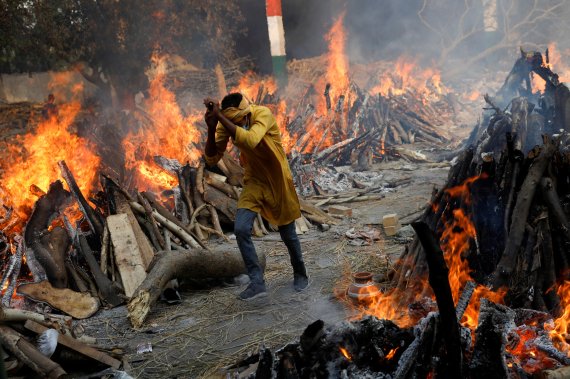인도는 코로나19 환자가 워낙 많아 제대로 치료 받기 힘든 상태로 사망자가 속출하고 있다. 사진은 뉴델리의 한 화장장에서 한 남성이 불길을 피해 화장장을 나오고 있는 모습. © 로이터=뉴스1 © News1