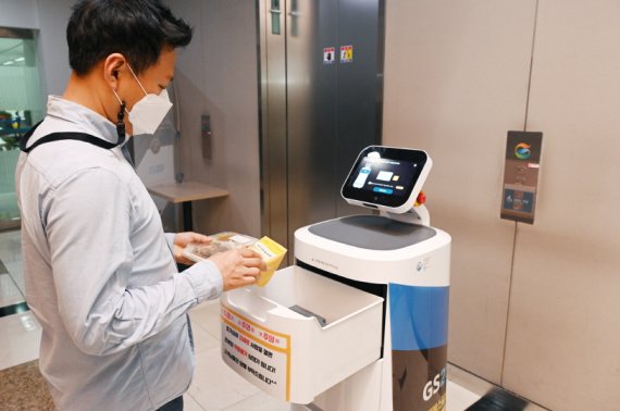 [서울=뉴시스] LG전자가 GS리테일과 함께 실내 로봇 배달 서비스를 확대한다. 서울 강남구 역삼동에 위치한 GS타워에서 ‘LG 클로이 서브봇(LG CLOi ServeBot)’이 고객에게 편의점 주문 물건을 전달하고 있다. (사진=LG전자 제공)