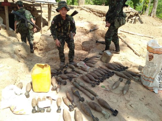 7일(현지시간) 미얀마 카렌주 무트로 지역에서 카렌 민족해방군의 한 병사가 미얀마군 초소에서 발견한 박격포탄 무더기 옆에서 박격포탄을 들고 있다. 반군 고위 간부는 카렌족 게릴라가 미얀마 군부대 전초기지를 점령해 불태웠다고 밝혔다.AP뉴시스