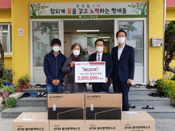 송봉호 BNK투자증권 시너지추진본부장(왼쪽 세번째)과 유성애 동보원 원장(왼쪽 두번째)이 지난 6일 나눔물품 전달식에서 기념촬영을 하고 있다. BNK투자증권 제공