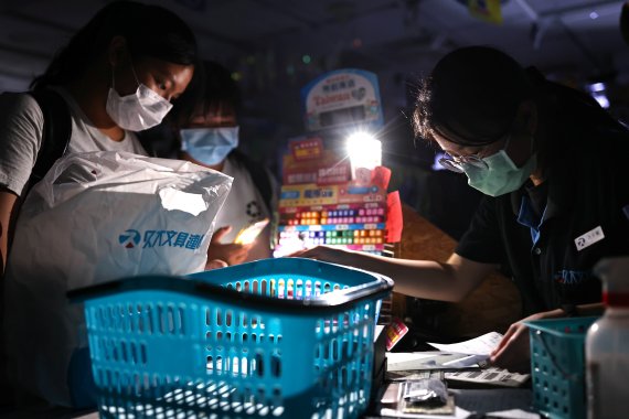 13일 대만 타이베이의 한 상점에서 손님들이 정전 사태로 인해 전구 불빛에 의존해 물건을 계산하고 있다.로이터뉴스1