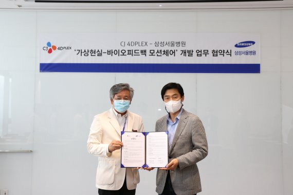 이규성 삼성서울병원 미래의학연구원장(왼쪽)과 김종열 CJ 4D플렉스 대표가 협약서를 교환하고 기념사진을 촬영하고 있다.