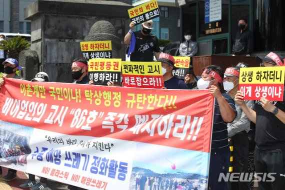 제주 지역 해루질(맨손 어업) 동호인들이 18일 제주도청 앞에서 해루질 금지를 내용으로 한 제주도의 고시 폐지를 촉구하고 있다. 제주도는 지난달 9일 야간 마을어장에서 수산동식물을 잡지 못 하도록 하는 내용의 ‘비어업인의 포획·채취 제한 및 조건’을 고시한 바 있다. 2021.05.18. [뉴시스]