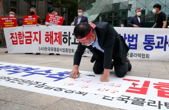 한국유흥업음식업중앙회가 지난 20일 서울시청 앞에서 열린 '형평성 맞는 방역수칙, 집합금지 해제 촉구 기자회견'에서 손실보상법 조속시행 등을 요구하고 있다./사진=뉴스1