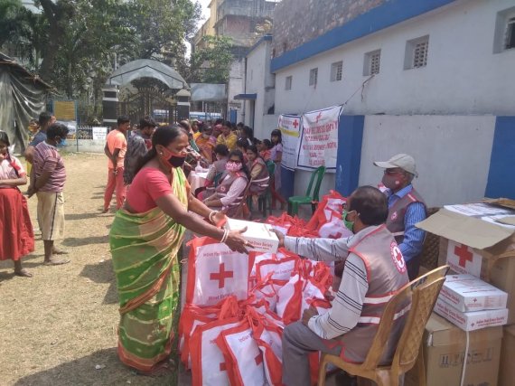 인도적십자사 직원들이 시민들에게 코로나19 긴급구호품을 전달하고 있다.