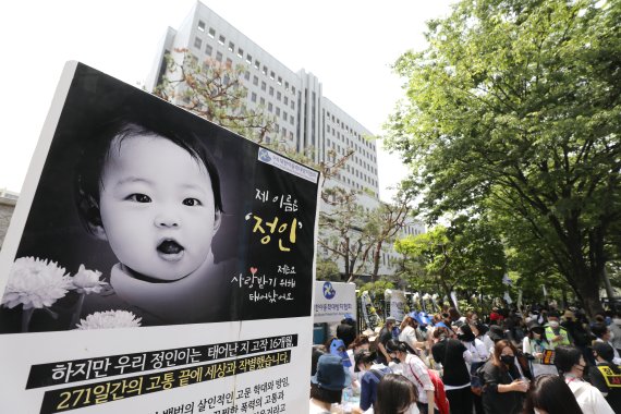 '정인이'의 양부모의 1심 선고 공판이 열린 지난 달 14일 오후 서울 양천구 서울남부지방법원 입구에서 시민들이 강력한 처벌을 촉구하는 피켓을 들고 있다. 뉴시스 제공