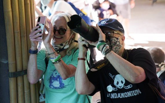 지난 5월21일(현지시간) 미국 워싱턴DC 스미스소니언 국립 동물원에서 관람객들이 재개장을 맞아 동물을 카메라에 담고 있는 모습.로이터뉴스1