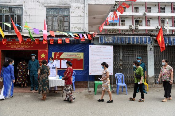 베트남 하노이의 한 지방선거 투표장에서 23일(현지시간) 간호사가 투표장에 들어오는 이들의 체온을 측정하고 있다. 베트남은 성공적인 방역 모범국가였지만 최근 수주일간 코로나19 바이러스가 급속히 확산하고 있다. 로이터뉴스1