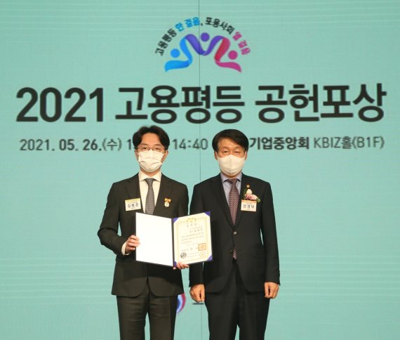 우아한형제들 김범준 대표(왼쪽)가 지난 26일 서울 여의도 중소기업중앙회에서 열린 ‘2021 고용평등 공헌포상 기념식’에서 고용평등 유공자 대통령 표창을 수상한 뒤, 안경덕 고용노동부 장관과 기념촬영을 하고 있다. 우아한형제들 제공