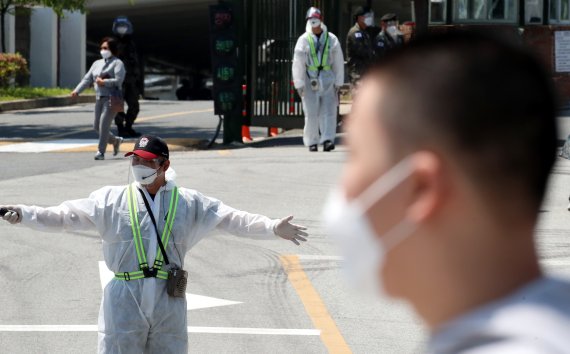 전투복 위해 방호복까지 겹쳐 입은 육군훈련소 조교가 입영심사대에서 입영장병들에게 이동 장소를 안내하고 있다. © News1