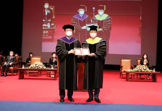 장제국 동서대 총장이 문주현 엠디엠그룹 회장(오른쪽)에게 명예박사 학위를 수여하고 있다. 사진=동서대 제공