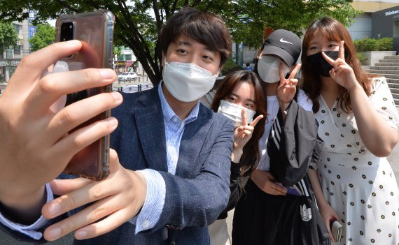 [대구=뉴시스]이무열 기자 = 이준석 국민의힘 전 최고위원이 24일 대구 북구 경북대학교 북문 앞에서 학생들과 셀카를 찍고 있다. 2021.05.24. lmy@newsis.com /사진=뉴시스