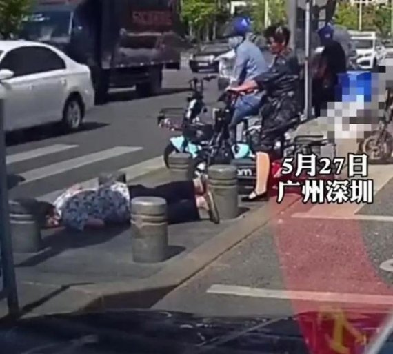 중국 선전시의 한 횡단보도에서 길을 건너던 노인이 차량 진입 방지 구조물에 걸려 넘어져 있다. 중국 매체 펑파이 캡쳐.