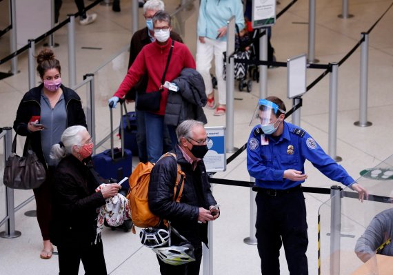 미국 워싱턴주 시택의 시애틀 타코마 국제공항에서 지난 4월 12일 방역 당국 직원들이 여행객을 안내하고 있다.로이터뉴스1