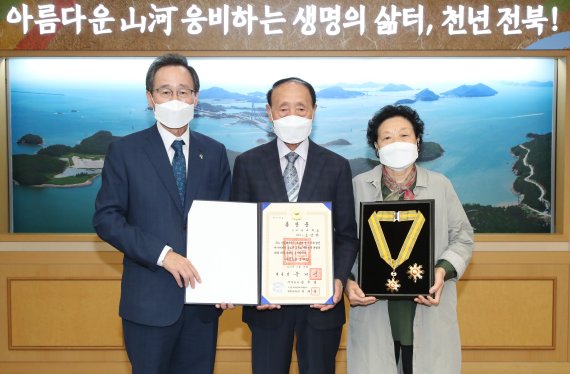 11일 제34주년 6·10 민주항쟁 기념 정부포상 전수식에서 송하진 전북도지사가 故 조성만 열사의 유족과 국민훈장 추서식을 갖고 있다. /사진=전북도