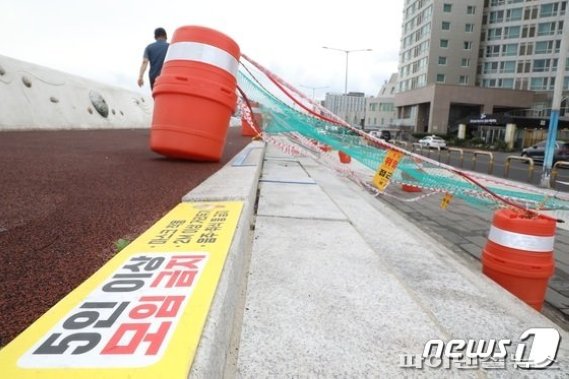 제주시가 탑동광장에 그물망을 설치한데 이어 12일부터 오후 10시 이후 가로등으로 소등한다고 밝혔다. 제주시 탑동광장이 음주를 즐기는 사람들로 붐비고 있다(위), 제주시는 사회적 거리두기를 강화하는 차원에서 광장에 플라스틱 드럼과 그물을 설치했다© 뉴스1