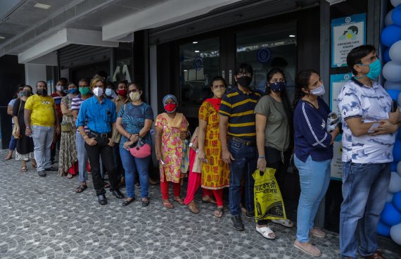 인도 콜카타에서 14일(현지시간) 코로나19 백신 접종소 앞에 사람들이 줄지어 서있다. AP뉴시스
