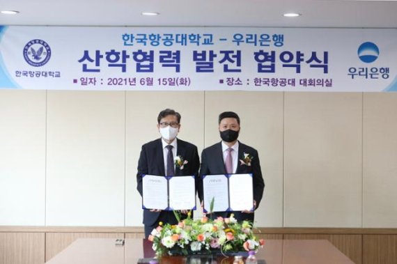 한국항공대학교 이강웅 총장(왼쪽)과 우리은행 권광석 은행장이 협약서에 서명한 후 기념촬영을 하고 있다. 사진=우리은행