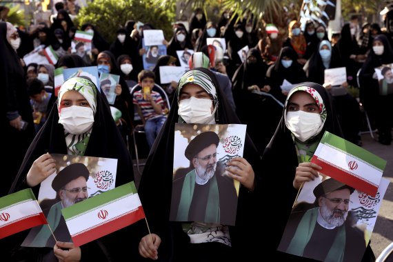 16일(현지시간) 이란 수도 테헤란에서 우파 후보 세예드 에브라힘 라이시의 지지자들이 그의 사진을 들고 행진하고 있다.AP뉴시스