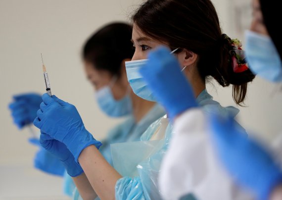 지난해 6월 일본 고베 지역의 대규모 백신 접종장에서 의료진들이 코로나19 백신을 들고 서 있다. 로이터 뉴스1