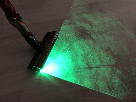 다이슨 V12 디텍트 슬림에 부착된 레이저가 바닥을 비추자 드러난 고양이 털. 사진=최용준 기자