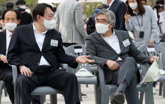 윤석열 전 검찰총장이 지난 9일 서울 중구 남산예장공원 개장식에서 이회영 선생의 증손자, 이종찬 전 국정원장 아들이자 친구인 이철우 연세대 교수와 대화하고 있다. © News1