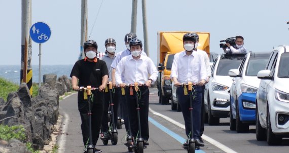 이준석 국민의힘 대표(앞줄 오른쪽)와 원희룡 제주도지사(앞줄 가운데)가 23일 오전 제주시 구좌읍 신재생에너지홍보관을 방문한 뒤 해안도로에서 전동킥보드를 타고 이동하고 있다. 뉴시스