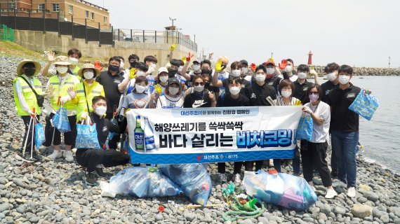 지난 26일 부산 해운대 청사포에서 대선주조 임직원과 시민들이 해안 정화 활동 비치코밍을 진행한 후 기념사진을 찍고 있다./제공=대선주조