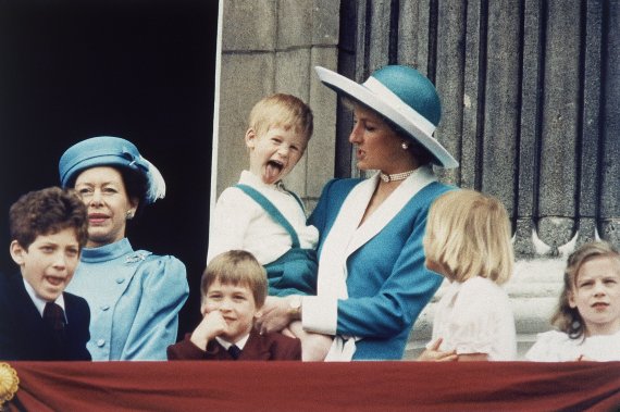 다이애나비 품에 안긴 해리 왕자가 카메라를 향해 혀를 내밀고 있다. 1988년 6월 버킹엄궁 발코니에서 찍은 영국 왕실가족 사진. /AP 뉴시스