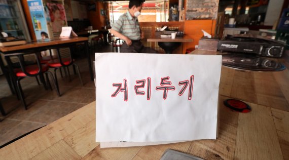 [서울=뉴시스]홍효식 기자 = 수도권의 새로운 사회적 거리두리 시행이 7일까지 1주일 연기된 가운데 1일 서울의 한 음식점에 4인 테이블 간 거리두기 안내문이 게시돼 있다. 2021.07.01. yesphoto@newsis.com