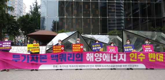 광주·전남 9개 시민단체·정당이 지난 6일 오전 서울 종로구 맥쿼리 사무실 앞에서 집회를 열고 맥쿼리의 해양에너지 인수 철회와 도시가스요금 인하를 촉구했다. 사진=참여자치21 제공. 뉴시스