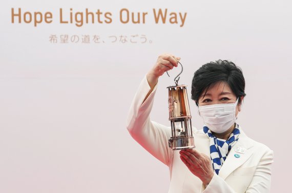 고이케 유리코 도쿄도지사가 9일 올림픽 성화가 도쿄에 도착한 것을 기념해 포즈를 취하고 있다. 지난 3월 25일부터 일본의 46개 광역지역을 순회한 올림픽 성화가 마지막 지역인 도쿄에 이날 도착했으나 코로나19 확산으로 도서 지역을 제외하고는 도로 봉송 행사가 취소됐다. 로이터 뉴스1