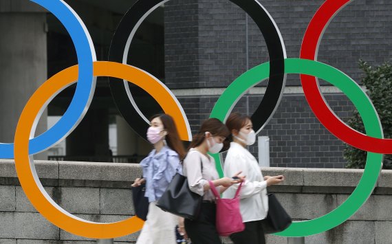 [도쿄=AP/뉴시스] 지난 8일 일본 도쿄에서 코로나19 확산 방지를 위해 마스크를 쓴 사람들이 도쿄 올림픽 오륜 조형물 앞을 지나가고 있다.<div id='ad_body3' class='mbad_bottom' ></div>