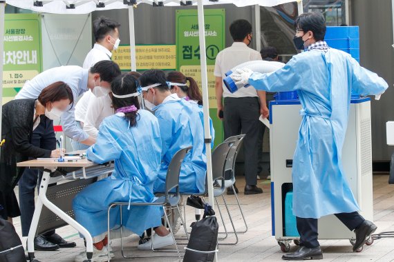 지난 13일 서울광장에 마련된 임시선별검사소에서 관계자가 냉풍기를 더 가까이 옮기고 있다. 뉴스1
