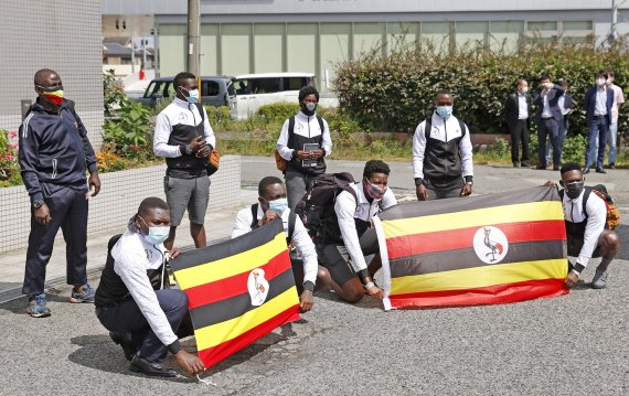 우간다 올림픽 대표팀이 지난달 20일 일본 오사카현 이즈미사노에 도착한 뒤 국기를 들고 기념촬영을 하고 있다. 로이터뉴스1