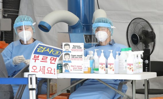 서울 노원구청 내 마련된 코로나19 선별검사소에서 의료진들이 선풍기로 더위를 견디고 있다. /사진=뉴스1