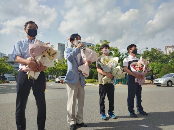 17년만에 출근하는 울산 남구청 전공노 해직 공무원들이 30일 출근길에 동료들이 전해준 축하 꽃다발을 들고 복직 소감을 말하고 있다.