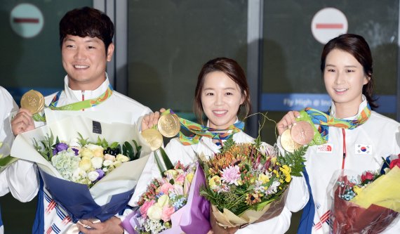 【인천공항=뉴시스】홍찬선 기자 = 대한민국 양궁대표팀이 2016 브라질 리우데자이네루 올림픽에서 전종목 석권의 쾌거를 이뤄내고 금의 환향했다. 16일 오후 인천공항에 입국한 이승윤, 장혜진, 기보배 선수가 금메달을 들어보이며 취재진에게 포토타임을 하고 있다. 2016.08.16. mania@newsis.com
