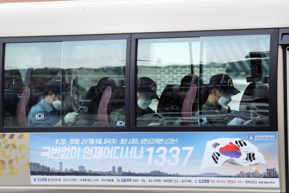 해외파병 임무 수행 중 신종 코로나바이러스 감염증(코로나19) 확진자가 발생한 청해부대 장병들을 태운 버스가 20일 오후 경기 성남 서울공항을 빠져나오고 있다. 이날 버스를 탄 청해부대원들이 휴대폰으로 바라보고 있다. 2021.7.20/뉴스1 © News1 황기선 기자